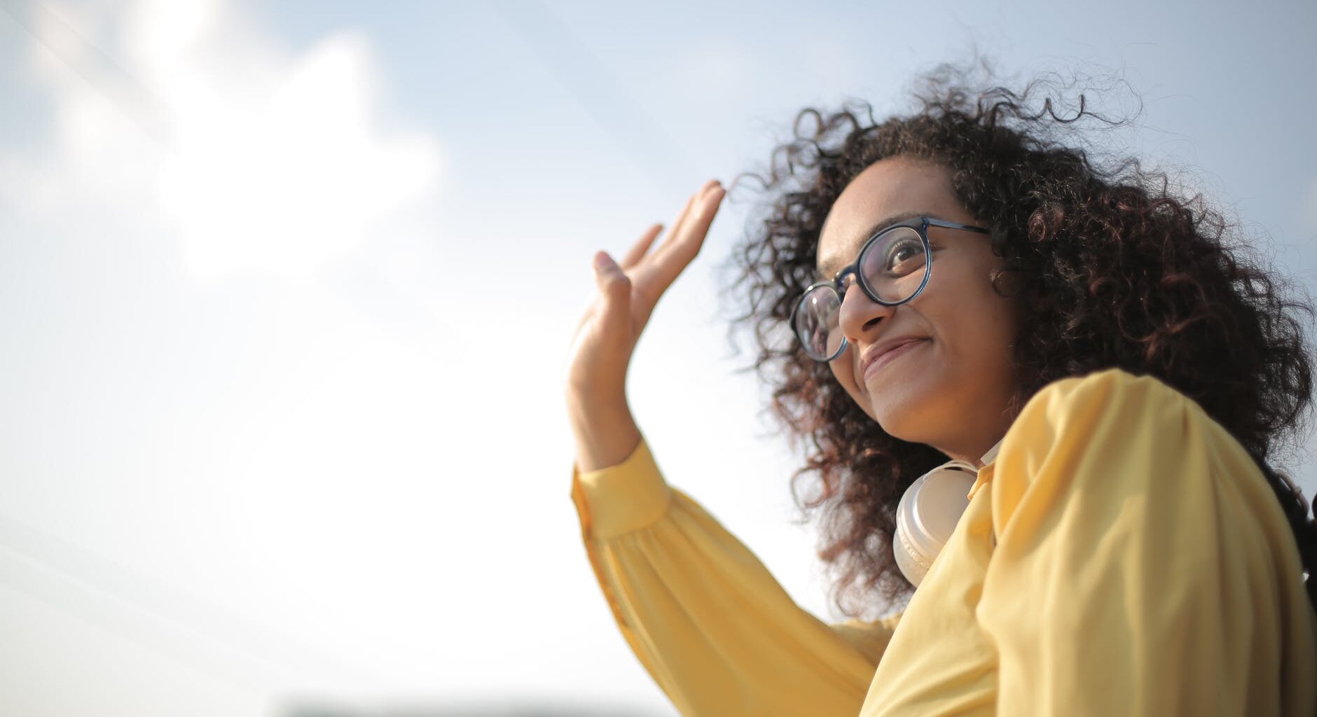 woman in yellow top waving